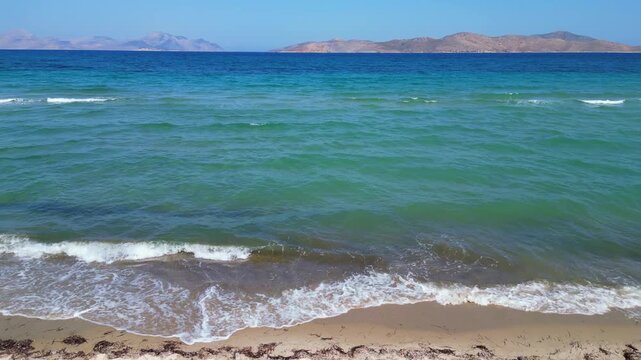 Drone footage capturing the wild and scenic sandy coastline of Flamingo beach with turquoise sea water near Tigkaki village on Kos island, Greece.