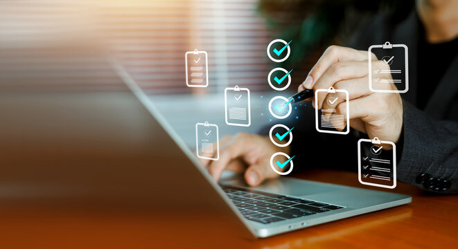 Businessman using laptop with virtual checklist and task management document icons. Concept of quality control, project approval, compliance, and successful task completion evaluation.