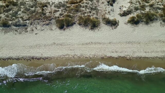 Drone footage capturing the wild and scenic sandy coastline of Flamingo beach with turquoise sea water near Tigkaki village on Kos island, Greece.