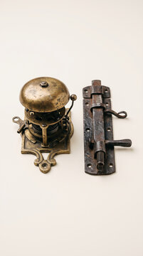 Vintage mechanical metal doorbell ringer on plain white wall