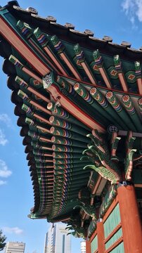 Vertical View of Traditional Korean Dancheong Paintings on Curved Eaves at Temple
