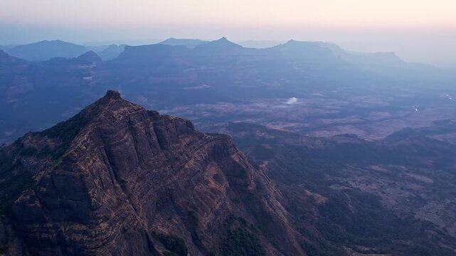 Aerial view of massive vertical rock walls carving through a vast and rugged wilderness landscape