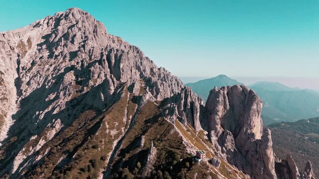 Majestic aerial footage flying alongside the stunning grigna mountain range in the italian alps, revealing the rosalba mountain hut