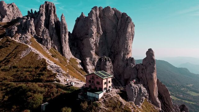 Drone view of the rosalba mountain hut nestled among the rocky spires of the southern grigna. Majestic alpine scenery in lombardy, italy