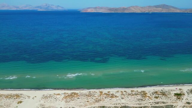 Drone footage capturing the wild and scenic sandy coastline of Flamingo beach with turquoise sea water near Tigkaki village on Kos island, Greece.