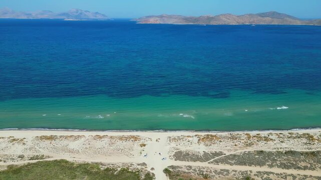 Drone footage capturing the wild and scenic sandy coastline of Flamingo beach with turquoise sea water near Tigkaki village on Kos island, Greece.