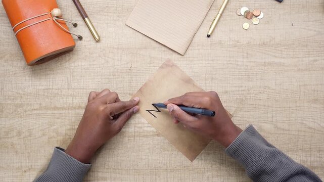 Person Writing New Year Goals on Vintage Paper
