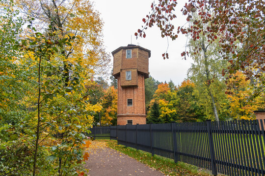 Historic water tower surrounded by colorful autumn foliage along a park walking path