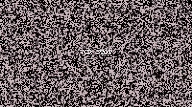 An analog television static noise pattern in black and pink displays white monospace text reading VCR STOP in the center