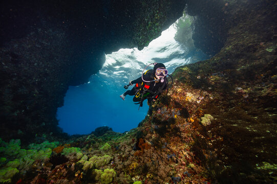 Scuba diver exploring a beautiful underwater sea cave