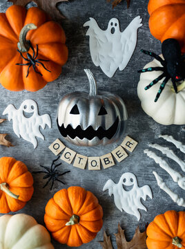 Spooky Halloween flat lay with pumpkins, ghosts and letter tiles