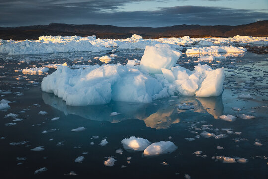 Icebergs floating in the arctic ocean at golden hour
