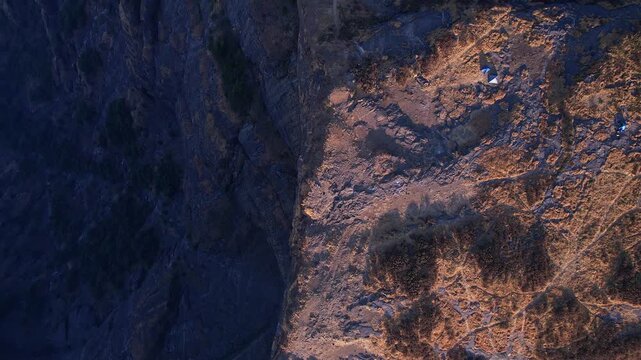Aerial landscape featuring towering stone walls across vast rugged terrain beneath blue skies