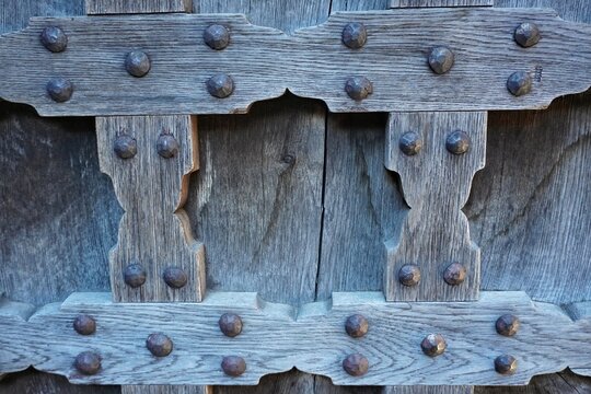 Close-up of ancient wooden castle door reinforced with heavy iron rivets and wrought metal studs