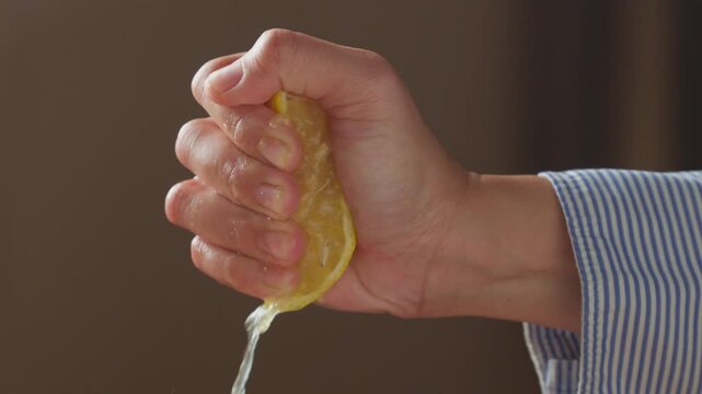 Squeezing a fresh lemon to extract its juice