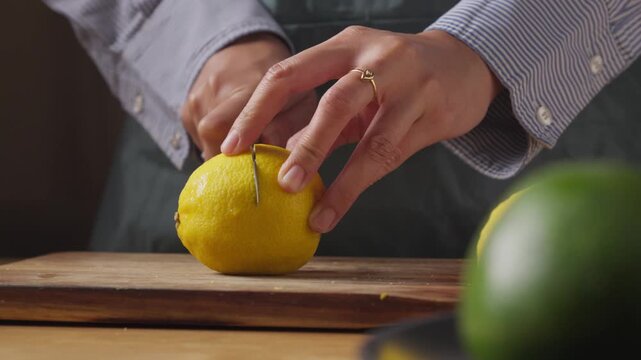 Person slicing a fresh lemon with a kitchen knife in a home kitchen