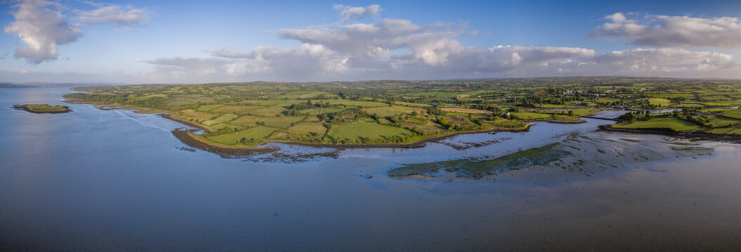 Aerial panoramic view of rural countryside and green shores along the scenic Shannon Estuary, Ireland. Green fields, tidal mudflats, and coastline along the Shannon Estuary in the west of Ireland.