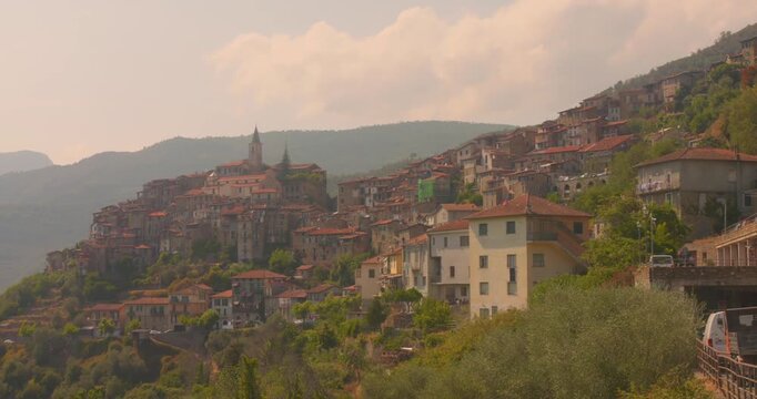 Hillside view of Apricale village with clustered stone houses and mountain backdrop