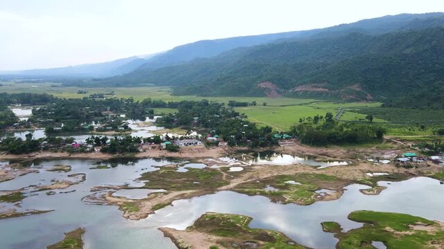 Stunning aerial footage of a mountain valley with a village nestled along a partially dry riverbed