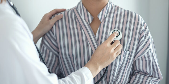 Doctor using stethoscope to examine patient heart and lungs for medical health checkup diagnosis and healthcare consultation concept