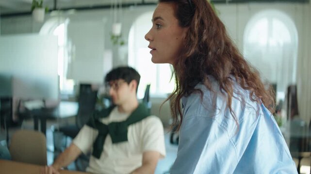 Woman leads a business meeting in the office, speaking while coworkers listen and contribute around the table. The scene highlights leadership, communication, teamwork, and active listening.