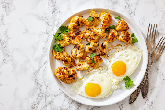 Cavolfiore al forno with fried eggs on a plate