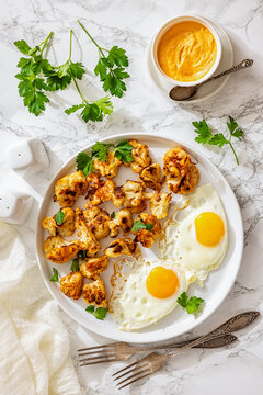 Chou fleur roti with fried eggs on plate