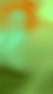 Abstract smooth blurred gradient background with vibrant green and orange tones.