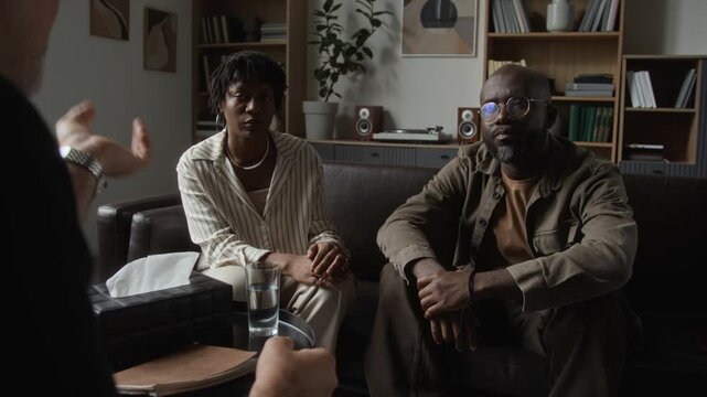 African American couple holding hands while listening to therapist during counseling session. Footage suitable for mental health campaigns and marriage therapy advertising
