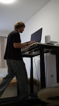 Vertical screen young man gets nervous while editing video at home struggling with technical problems and pressure during a demanding creative work session