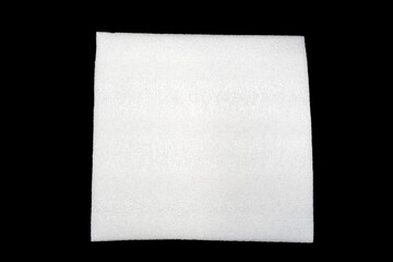 White square textured foam pad or fabric sheet isolated on a black Background, shown from above with soft edges. © Mukta