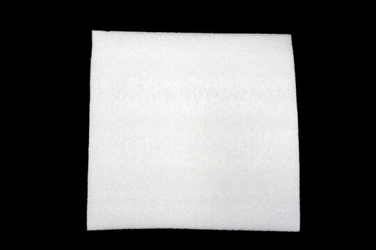White square textured foam pad or fabric sheet isolated on a black Background, shown from above with soft edges.
