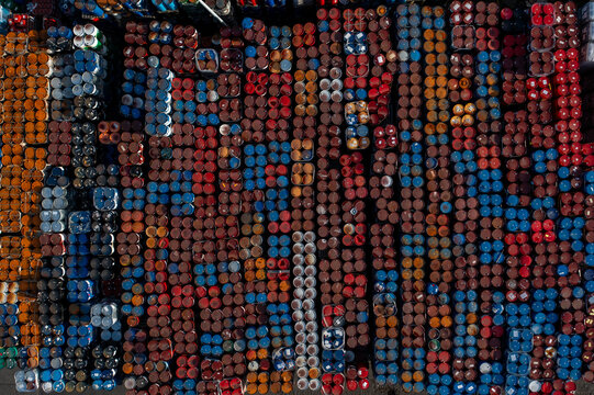 Aerial view of a large collection of colorful industrial barrels arranged in rows in an outdoor storage yard in Roeselare, Flanders, Belgium.
