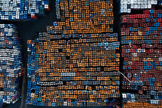 Aerial view of a large industrial storage yard filled with rows of colorful chemical barrels in Roeselare, Flanders, Belgium.