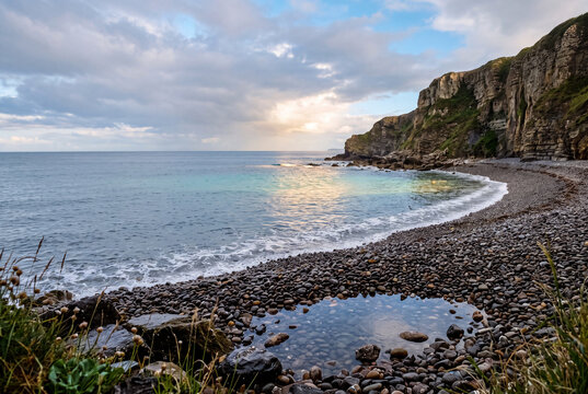 Quiet rocky beach with coastal cliffs and gentle waves