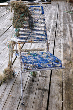 Three-legged chair covered with shells and marine debris recovered from the sea by a fishing boat