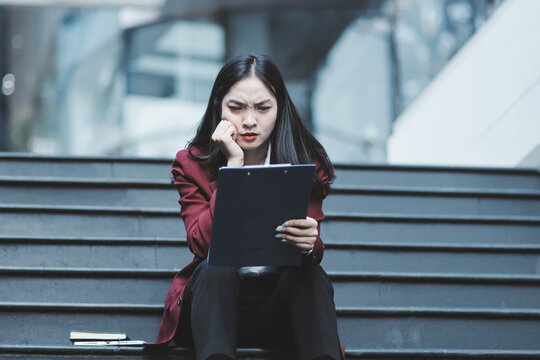 desperate Asian Korean business woman crying alone sitting on street staircase suffering stress and depression crisis being victim of mobbing or fired losing her job
