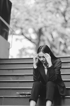 desperate Asian Korean business woman crying alone sitting on street staircase suffering stress and depression crisis being victim of mobbing or fired losing her job