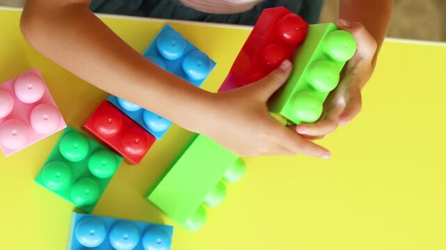 Experience the wonder of creativity as a child's hands assemble colorful blocks. This video showcases the essential role of constructive play in nurturing fine motor skills and engineering thought.