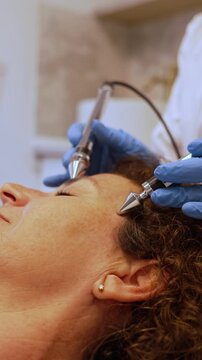 Mature woman receiving facial microcurrent therapy treatment