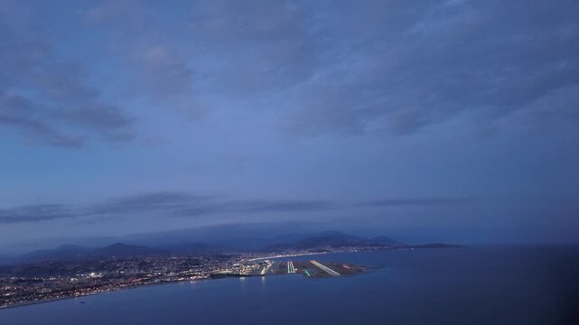 immersive pilot perspective from the cockpit of a jet airplane doing the final turn to align with the illuminated runway. 04, with a view of French Riviera lights under a twilight sky. 4K shot