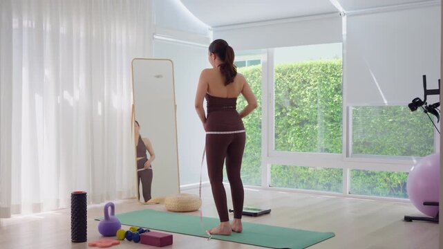 Rear view people young adult asian woman self tape measure leg hip size shape lean body mass index fat track weight loss perimenopause life anti aging diet preventive modern medicine asia health care.