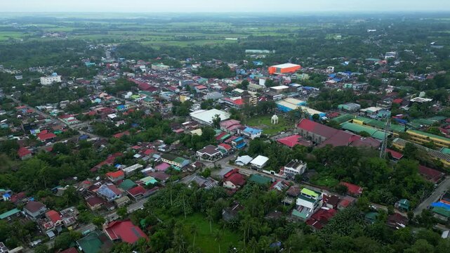 Wide aerial drone view of Goa town in Camarines Sur, Philippines, showing the urban landscape and main transportation corridor along Governor Jose T. Fuentebella National Highway. Footage captures com