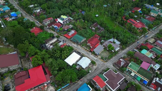 Wide aerial drone view of Goa town in Camarines Sur, Philippines, showing the urban landscape and main transportation corridor along Governor Jose T. Fuentebella National Highway. Footage captures com