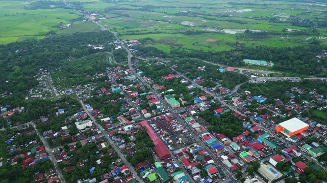 Cinematic aerial view of the commercial center of Goa, Camarines Sur, Philippines, featuring 101 Shopping Center and surrounding businesses along the Governor Jose T. Fuentebella National Highway. Dro