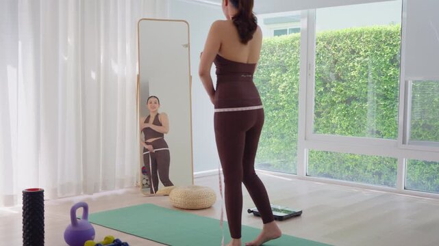 Rear view people young adult asian woman self tape measure leg hip size shape lean body mass index fat track weight loss perimenopause life anti aging diet preventive modern medicine asia health care.