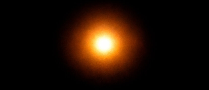 Intense orange radial light flare with a bright glowing central core
