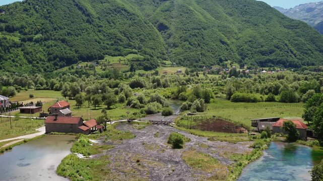 Panoramic aerial view of a scenic mountain valley where rivers and lakes meet, surrounded by majestic mountains and pristine wilderness.
