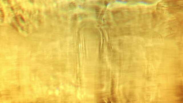 Warm sunlight refracts through a faceted crystal vase, casting flowing golden caustics and abstract glowing patterns in close-up.