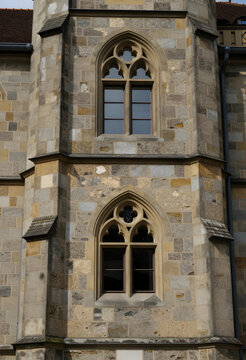 Heritage conservation and historical architecture, gothic stone windows on a medieval castle facade with textured masonry and traditional craftsmanship